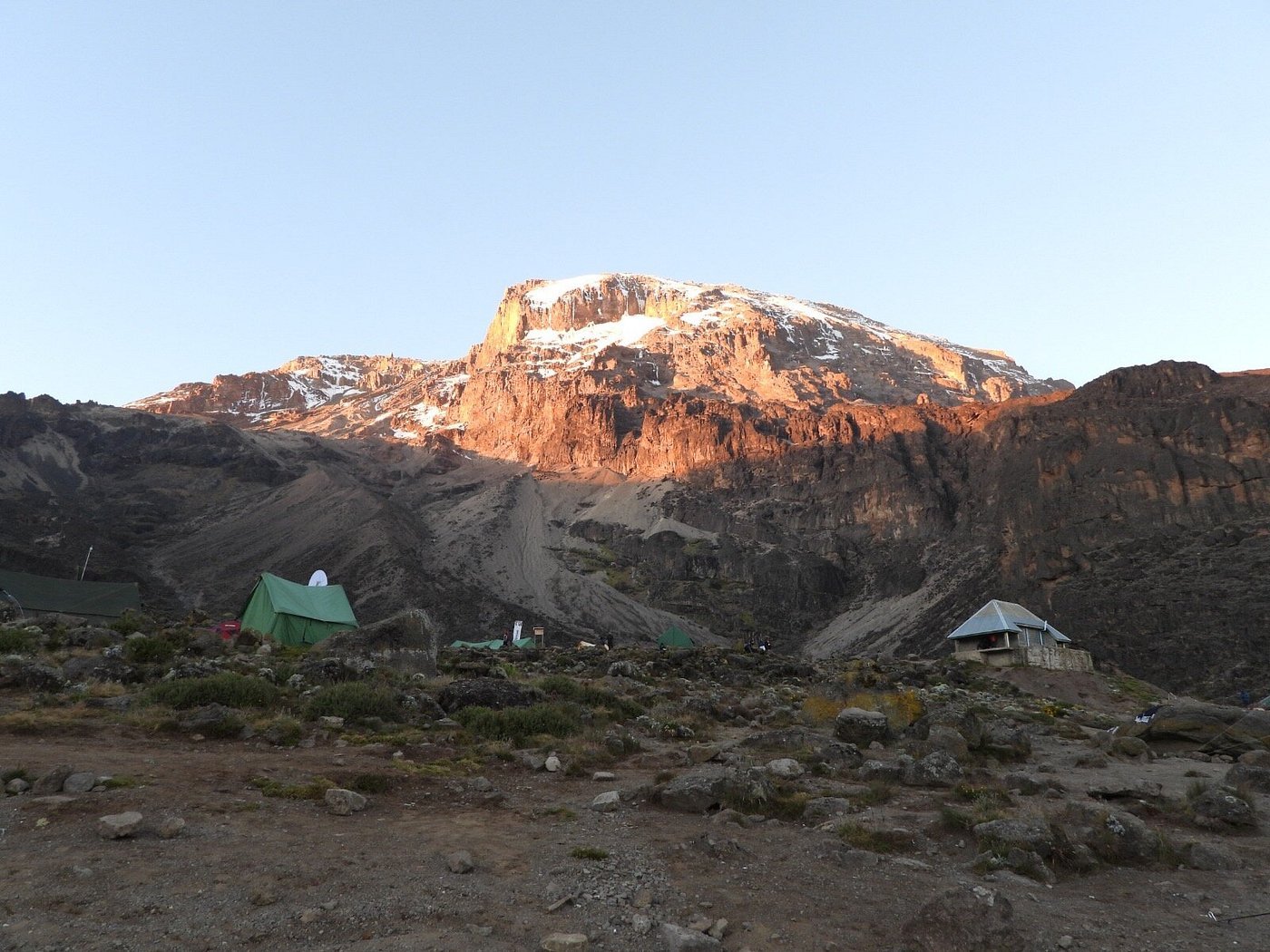 A high mountain camp beneath Kilimanjaro in warm evening light